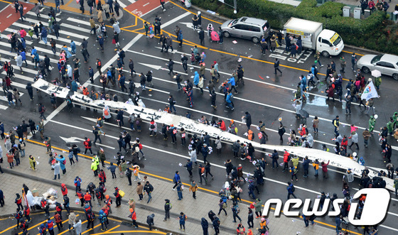 '비선실세' 최순실씨의 국정농단 사건 책임을 물어 박근혜 대통령 퇴진을 요구하는 5차 촛불집회가 26일 오후 서울 광화문 광장과 일대 도로에서 열린 가운데 민중미술가 임옥상이 500m 천 퍼포먼스를 진행하고 있다. 이날 촛불집회는 서울뿐 아니라 부산·대구·광주·울산 등 전국 56개 지역에서 동시다발적으로 열렸다. 주최 측이 예상하는 참가 인원은 서울에서만 150만 명, 전국적으로는 최대 200만명 명이다.(사진공동취재단) 2016.11.26/뉴스1 © News1 사진공동취재단