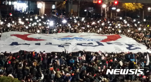 【부산=뉴시스】 하경민 기자 = 3일 오후 부산 부산진구 서면 중앙로에서 박근혜정권퇴진 부산운동본부 주최로 열린 제5차 부산시국대회에 참가한 시민과 학생 등 주최 측 추산 20만명, 경찰 추산 2만3000명이 거리행진을 펼쳐 문현교차로에 집결한 뒤 대형 새누리당 기를 찢고 있다. 2016.12.03. (사진=부산경찰청 제공).   yulnetphoto@newsis.com