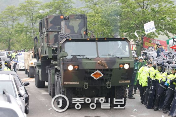 주한미군의 고고도미사일방어(THAAD) 체계에 사용되는 군 장비가 26일 오전 경북 성주군 초전면 소성리 마을회관 앞을 지나 성주골프장으로 향했다. 오전 4시43분 1차 군 장비 이동에 이어 2시간 뒤인 오전 6시45분경에 2차 군 장비가 마을회관 부근을 지나고 있다. 사드 배치를 반대하는 주민들이 던진 나무토막과 생수통이 차량에 날아들고 있다. 성주=프리랜서 공정식 / 2017.04.26