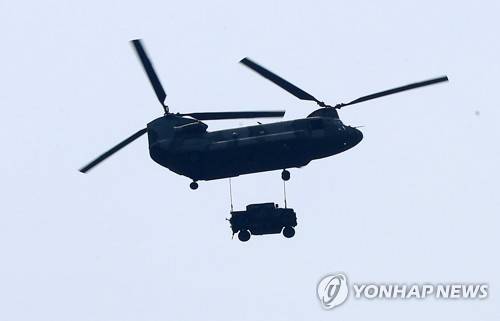 (성주=연합뉴스) 김준범 기자 = 31일 오후 경북 성주군 초전면 소성리 마을회관 위로 비행하는 미군 헬기가 차량을 성주골프장까지 운반하고 있다. 2017.5.31