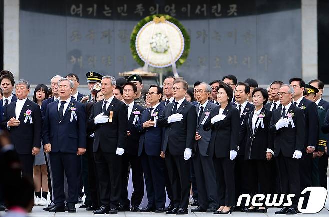 문재인 대통령과 영부인 김정숙 여사가 6일 오전 서울 동작구 국립서울현충원에서 열린 제62회 현충일 추념식에서 주요 내빈 등과 헌화 및 분향을 마친 뒤 밖으로 나오며 국기에 대한 경례를 하고 있다. 2017.6.6/뉴스1 © News1 박정호 기자