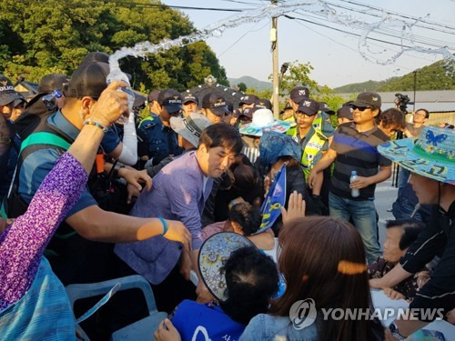 (성주=연합뉴스) 최수호 기자 = 15일 오후 사드(THAAD·고고도미사일방어체계) 배치 부지인 경북 성주군 초전면 소성리 마을회관 인근 도로에서 경찰이 주민이 차량 검문을 위해 설치한 책상을 치우려고 하자 주민이 막고 있다. 2017.6.15