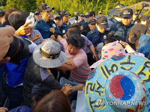 (성주=연합뉴스) 최수호 기자 = 15일 오후 사드(THAAD·고고도미사일방어체계) 배치 부지인 경북 성주군 초전면 소성리 마을회관 인근 도로에서 경찰이 주민이 차량 검문을 위해 설치한 책상을 치우려고 하자 주민이 막고 있다. 2017.6.15