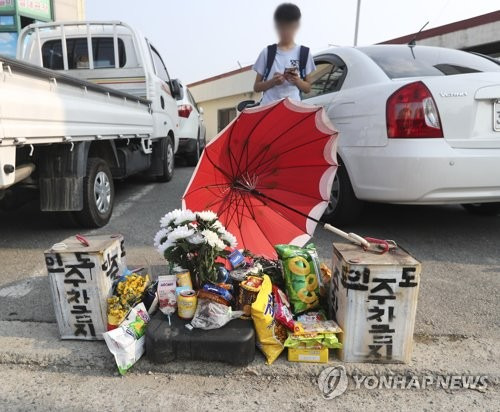 (청주=연합뉴스) 이승민 기자 = 지난 15일 어린이 보호구역 도로변을 걷다 시내버스에 치여 숨진 초등학생을 애도하는 발길이 이어지고 있다. 19일 A(11)군이 변을 당한 청주시 흥덕구 옥산면 길가에는 그의 친구, 유가족, 이웃들이 가져다 놓은 과자와 꽃, 빨간색 우산이 놓였다. 2017.6.19      photo@yna.co.kr