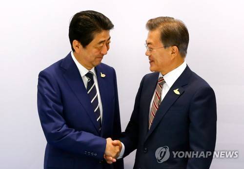 (함부르크=연합뉴스) 배재만 기자 = 문재인 대통령과 아베 신조 일본 총리가 7일 오전(현지시간) 독일 함부르크 G20 정상회의장 메세홀 양자회담장에서 열린 한-일 정상회담에서 만나 악수하며 눈빛을 교환하고 있다. 2017.7.7 scoop@yna.co.kr