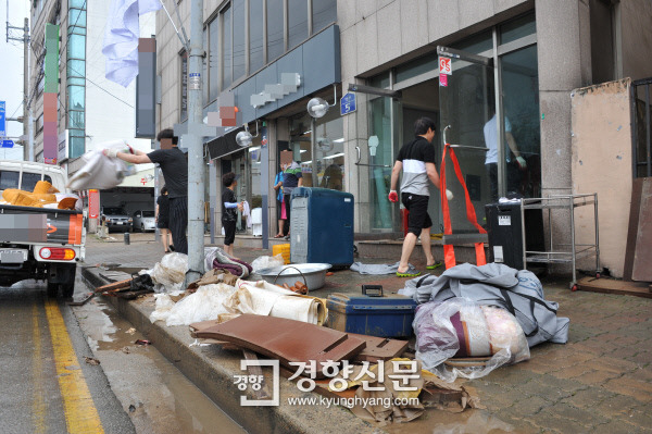 지난 17일 충북 청주시 흥덕구 모충동에서 상인들이 전날 290.2㎜의 폭우로 침수된 물건들을 정리하고 있다. ｜이삭 기자