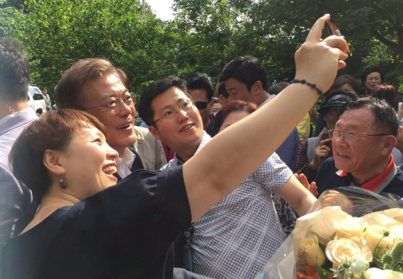 문재인 대통령이 21일 오후 경남 양산시 사저 앞에서 환영나온 지역 주민과 셀카를 찍고 있다.청와대제공