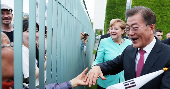 5일 오후(현지시간) 베를린 연방총리실에서 만난 문 대통령과 메르켈 총리가 만찬회담 뒤 총리실 담장 밖에 있는 교민들에게 다가가 인사하고 있다. [청와대사진기자단]