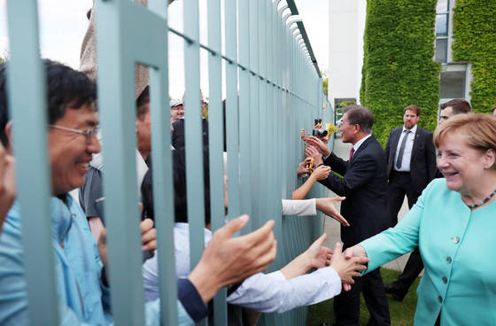 5일 오후(현지시간) 베를린 연방총리실에서 만난 문 대통령과 메르켈 총리가 만찬회담 뒤 총리실 담장 밖에 있는 교민들에게 다가가 인사하고 있다. [청와대사진기자단]