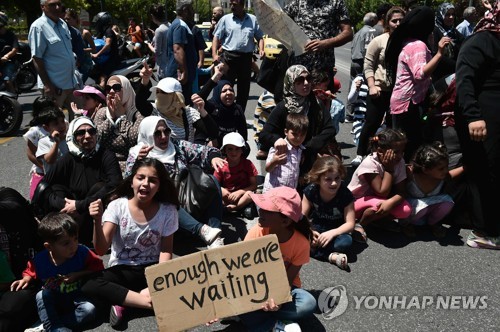 시리아 난민들이 주 그리스 독일대사관 앞에서 독일에 있는 가족과의 재결합 지연에 항의하고 있는 모습 [AFP PHOTO / LOUISA GOULIAMAKI=연합뉴스]