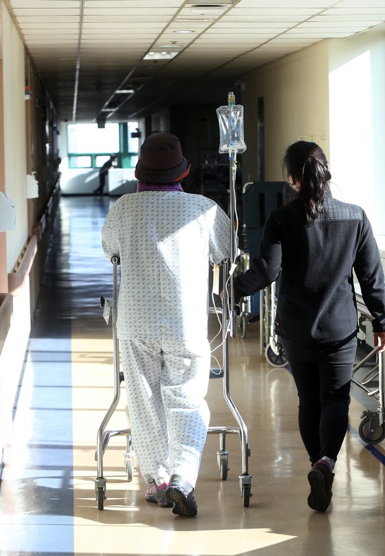 일산 국립암센터 입원 병동에서 한 여성 암환자가 링거 주사를 맞으며 운동 삼아 병원 복도를 돌고 있다. [중앙포토]