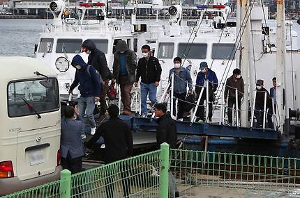 지난 28일 경북 울진 후포항에 도착한 391흥진호 선원이 얼굴을 가린 채 배에서 내려 버스에 타고 있다