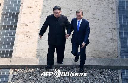 문재인 대통령(오른쪽)과 김정은 북한 국무위원장이 27일 오전 판문점 군사분계선을 넘고 있다./AFPBBNews=뉴스1