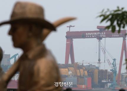 칼을 든 동상 너머로 울산 현대중공업의 대형 크레인이 보이고 있다. / 연합뉴스