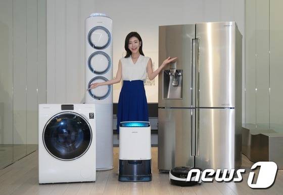 삼성전자 모델이 18일 삼성전자 수원사업장 생활가전동 프리미엄 하우스에서 ´인버터 컴프레서´와 ´인버터 모터´의 무상보증 기간이 10년으로 일원화된 삼성 생활가전 제품들을 소개하고 있다. (왼쪽부터 시계방향으로 WW900 세탁기, 스마트에어컨 Q9000, 셰프컬렉션 냉장고, 파워봇 로봇청소기, 2015년형 인버터제습기)© News1