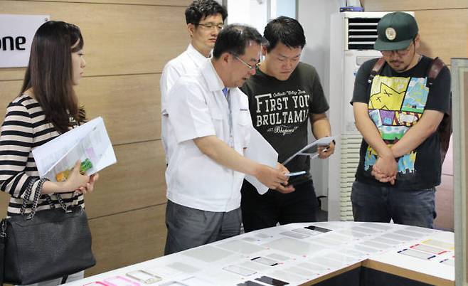 류종윤 화이트스톤 대표(왼쪽 두 번째)가 자체 개발한 스마트폰 액정 보호 강화유리에 대해 설명하고 있다.