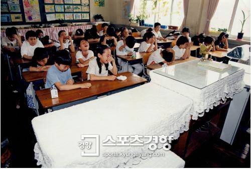 삼풍백화점 붕괴사고로 숨진 선생님의 교탁을 보며 울고 있는 영희초교 4학년4반 어린이들.