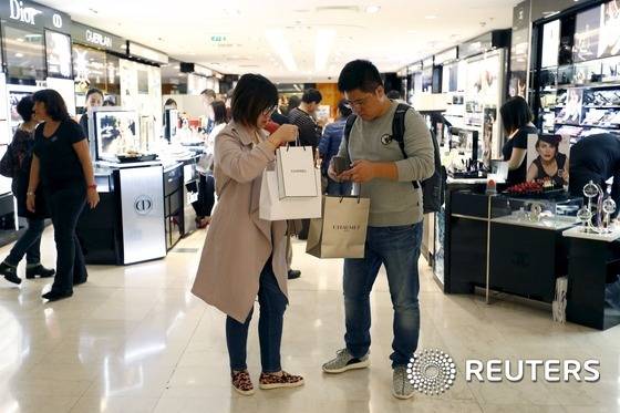 프랑스 파리 갤러리 라파예트 백화점에서 아시아 소비자들이 구입한 물건을 살펴보고 있다. 2015.9.23 © 로이터=News1