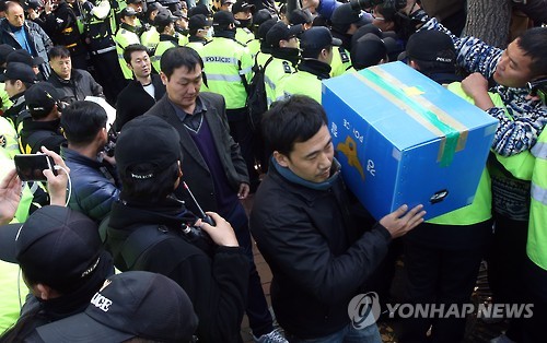 민주노총 본부 등을 압수수색한 경찰이 21일 오후 서울 중구 정동 민노총에서 압수물을 들고 나오고 있다.