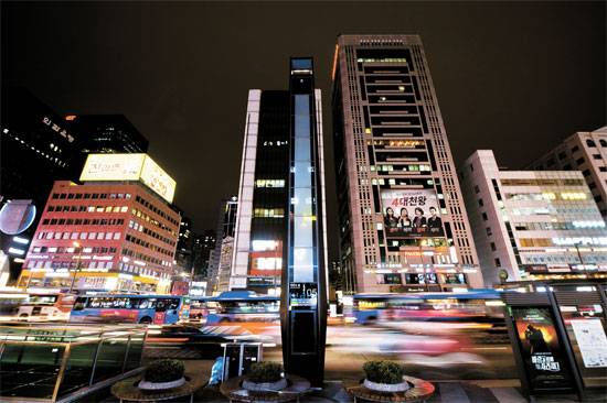 지난달 26일 오후 강남역 11번 출구 앞에 불이 꺼진 미디어폴(가운데) 모습. 강남대로에 총 22개가 있다. 환하게 불이 켜진 맞은 편 건물과 대조된다. [김경록 기자]