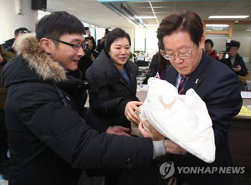 사진은 2016년 성남시 공공산후조리지원 1호 가족의 아기를 안아보는 이재명 성남시장(오른쪽)