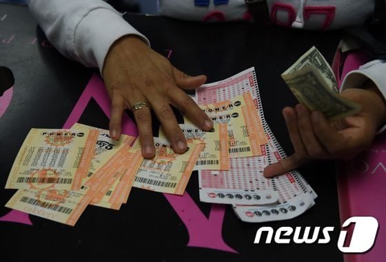 13일 (현지시간) 캘리포니아 주 호손의 파워볼 복권 명당 판매소로 알려진 가게에 한 손님이 복권을 사고 있다. © AFP=뉴스1