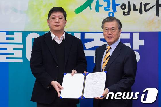 고 김대중 전 대통령의 3남 김홍걸 연세대 김대중도서관 객원교수가 24일 서울 여의도 국회에서 더불어민주당 입당 기자회견을 마친 후 문재인 대표에게 입당원서를 전달하고 있다. 2016.1.24/뉴스1 © News1 유승관 기자