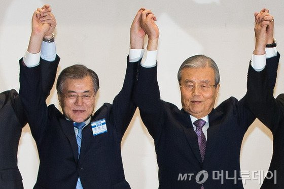 문재인 더불어민주당 대표가 27일 서울 여의도 국회 의원회관에서 열린 제4차 중앙위원회의에서 지도부 총사퇴를 선언한 뒤 김종인 비대위원장 겸 선대위원장을 비롯한 비대위원들과 손을 들어보이고 있다. 문 대표는 이 자리에서 당 대표로 선출된 후 353일만에 김종인 위원장에게 전권을 이양하고 총선정국에서 백의종군한다. 2016.1.27/뉴스1  <저작권자 &#169; 뉴스1코리아, 무단전재 및 재배포 금지>