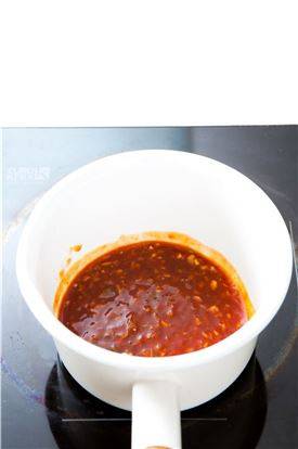 4. 달군 팬에 참기름을 두르고 다진 양파, 다진 대파를 넣어 볶다가 두반장을 넣고 청주, 토마토케첩, 간장을 넣어 끓인 후 통깨를 넣고 섞는다.