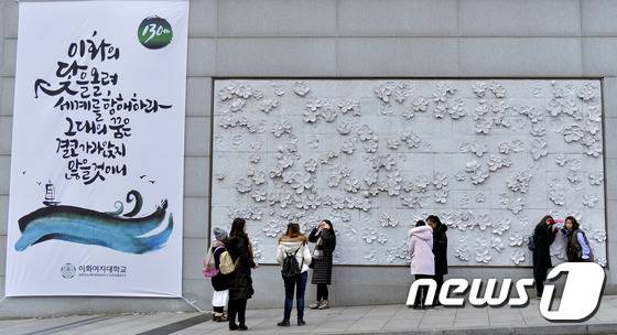 이화여자대학교에서 4번째 '이화글판'을 선보인 28일 시민과 관광객들이 서울 서대문구 이화여대 정문 '이화글판' 옆에서 기념촬영을 하고 있다.  (이화여대 제공) 2016.1.28/뉴스1 © News1