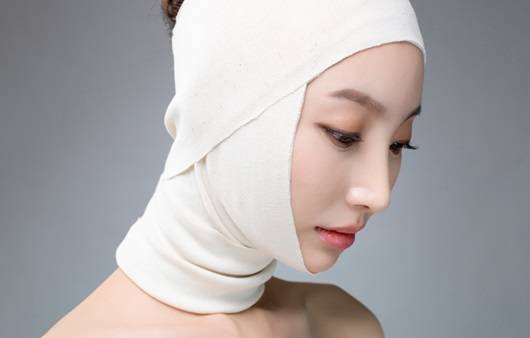 성형후 얼굴에 붕대를 감은 여성