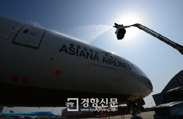 아시아나 항공 직원들이 인천공항 아시아나항공 정비고에서 특수장비를 이용해 비행기 동체 외부를 세척하고 있다. 김영민 기자 viola@kyunghyang.com