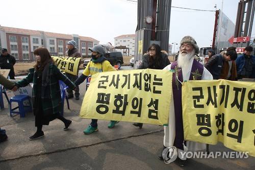 제주해군기지 반대 인간띠     (서귀포=연합뉴스) 고성식 기자 = 26일 준공식이 열리는 제주민군복합형관광미항(제주해군기지)의 정문 앞 부근에서 제주 서귀포시 강정마을 주민과 기지 건설을 반대하는 활동가들이 인간띠 잇기를 하고 있다. 2016.2.26     koss@yna.co.kr