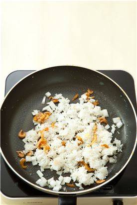 3. 팬에 식용유를 두르고 양파와 잔새우를 볶다가 양파가 투명해지면 밥을 넣어 볶은 후 소금, 후춧가루로 간을 한다.