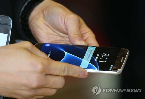 이것이 S7     (서울=연합뉴스) 김도훈 기자 = 삼성전자 스마트폰 갤럭시S7과 갤럭시S7엣지 출시일인 11일 오전 서울 광화문 KT스퀘어에서 한 시민이 제품을 확인해보고 있다.