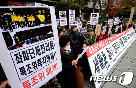 대한민국어버이연합 등 보수단체 회원들이 24일 오후 서울 중구 저동 4ㆍ16세월호참사 특별조사위원회 입주 건물 앞에서 특조위 해체 촉구 집회를 하고 있다. 2015.11.24/뉴스1 © News1 박정호 기자