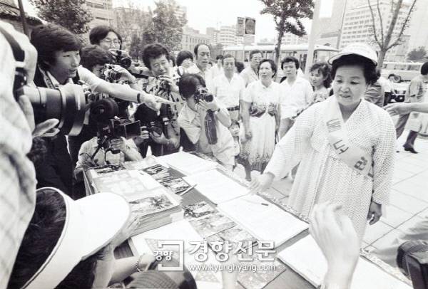 1980년대 서울 시내에서 열린 저출산 권장 캠페인에서 당시 김정례 보건사회부 장관이 ‘둘도 많다’는 어깨띠를 두르고 서명에 참여하고 있다. 당시 인구 캠페인의 구호는 “둘도 많다. 하나씩만 낳아도 삼천리는 초만원”이었다. 경향신문 자료사진