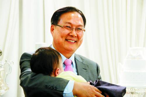 소년원 출신 '딸'을 둔 윤용범 서기관이 지난 주말 경기도 안양 비산동의 한 뷔페에서 열린 돌잔치에서 재롱을 부리다 잠든 '손자'를 안고 기뻐하고 있다.