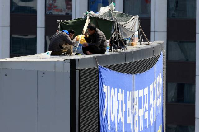 지난 4월 5일 오후 최정명씨왼쪽)와 한규협씨가 서울 중구 옛 국가인권위원회 옥상 광고탑 위 농성장에서 늦은 점심식사를 하고 있다. 김태형 기자 xogud555@hani.co.kr