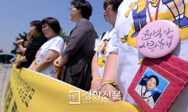 “진실을” 20일 서울 국회의사당 앞 ‘19대 국회의 세월호특별법 개정과 특검 무산에 대한 입장발표’ 기자회견에 참여한 한 유가족이 자녀의 사진을 걸고 서 있다. 서성일 기자 centing@kyunghyang.com