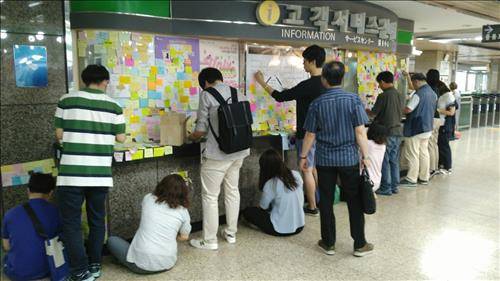 27일 오후 구의역 사고 시민대책위 관계자들이 추모 포스트잇을 보관 공간으로 옮기기 위해 떼고 있다.