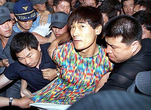 1999년 7월 16일, 도피 중이던 탈옥수 신창원이 전남 순천의 한 아파트에서 체포돼 경찰에 압송되고 있다. 그가 입은 화려한 티셔츠는 세간의 화제를 불러 일으켰다. 한국일보 자료사진