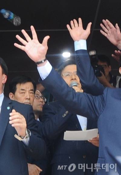 황교안 국무총리가 15일 경북 성주군청에서 사드관련 상황에 대해 발언을 하는 가운데 관계자들이 사드배치에 반대하는 성주군민들이 던진 물병과 계란 등을 막고 있다./사진=뉴스1