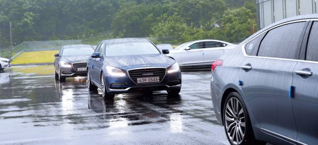 거센 장마비가 쏟아지는 가운데 지난 16일 개최된 ‘제네시스 G80 익스피리언스’ 행사에서 시승차량들이 출발을 기다리고 있다. 이날 행사에는 자동차 동호회원, 파워블로거 등 일반인 60여명이 초청됐다. [사진제공=현대자동차]