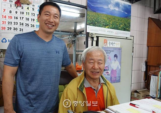 팔판정육점 2대와 3대를 잇는 이경수·준영(완쪽)씨 부자가 집무실이라 할 수 있는 책상 앞에 나란히 자리했다. 수십 년 써온 출납장부 앞에서 웃는 표정은 순조로운 대물림을 보여주는 듯하다.