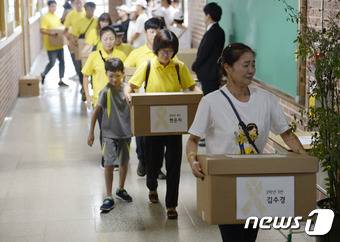 20일 경기 안산 단원고등학교에서 세월호 참사 희생자 유가족들이 기억교실(존치교실) 임시 이전을 위해 유품을 현관으로 옮기고 있다. 2016.8.20/뉴스1 © News1 안은나 기자