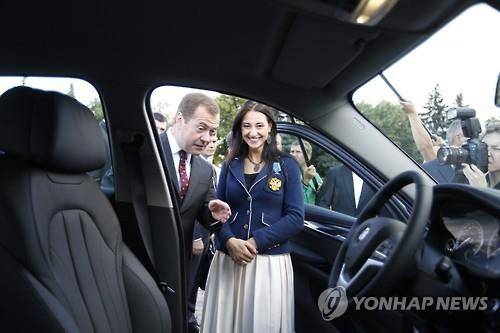 드미트리 메드베데프 총리가 25일 크렘린궁에서 리우 올림픽 우승자들에게 부상으로 선물하는  BMW X6 차량을 보여주고 있다. [EPA=연합뉴스]