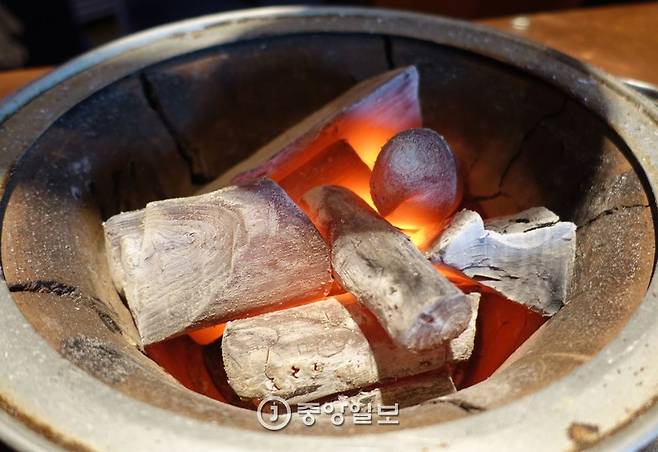 최고급 숯 백탄 가운데서도 으뜸인 비장탄 숯불. 2.5kg의 두꺼운 주물 불판이 300도로 달궈져야 양고기가 가장 맛있게 구워지는데 다른 숯으로는 그 온도가 안 나온다.