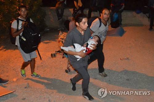 그리스 난민캠프서 화재…난민 3천~4천명 탈출 (레스보스섬 EPA=연합뉴스) 그리스 레스보스섬의 한 난민 캠프에서 19일(현지시간) 방화로 인한 화재가 발생, 난민 3천∼4천 명이 캠프를 탈출하는 사태가 발생했다. 사진은 난민들이 불길을 피해 황급히 캠프를 빠져나가는 모습.