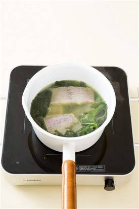 4. 국물이 끓으면 물 2컵을 더 넣고 끓인다. 끓어오르면 가자미를 넣고 센 불로 끓여 끓으면 중간 불에 10분 정도 끓인다. 다진 마늘과 다진 파를 넣고 미역이 부드러워지면 국간장과 소금으로 간을 한다.